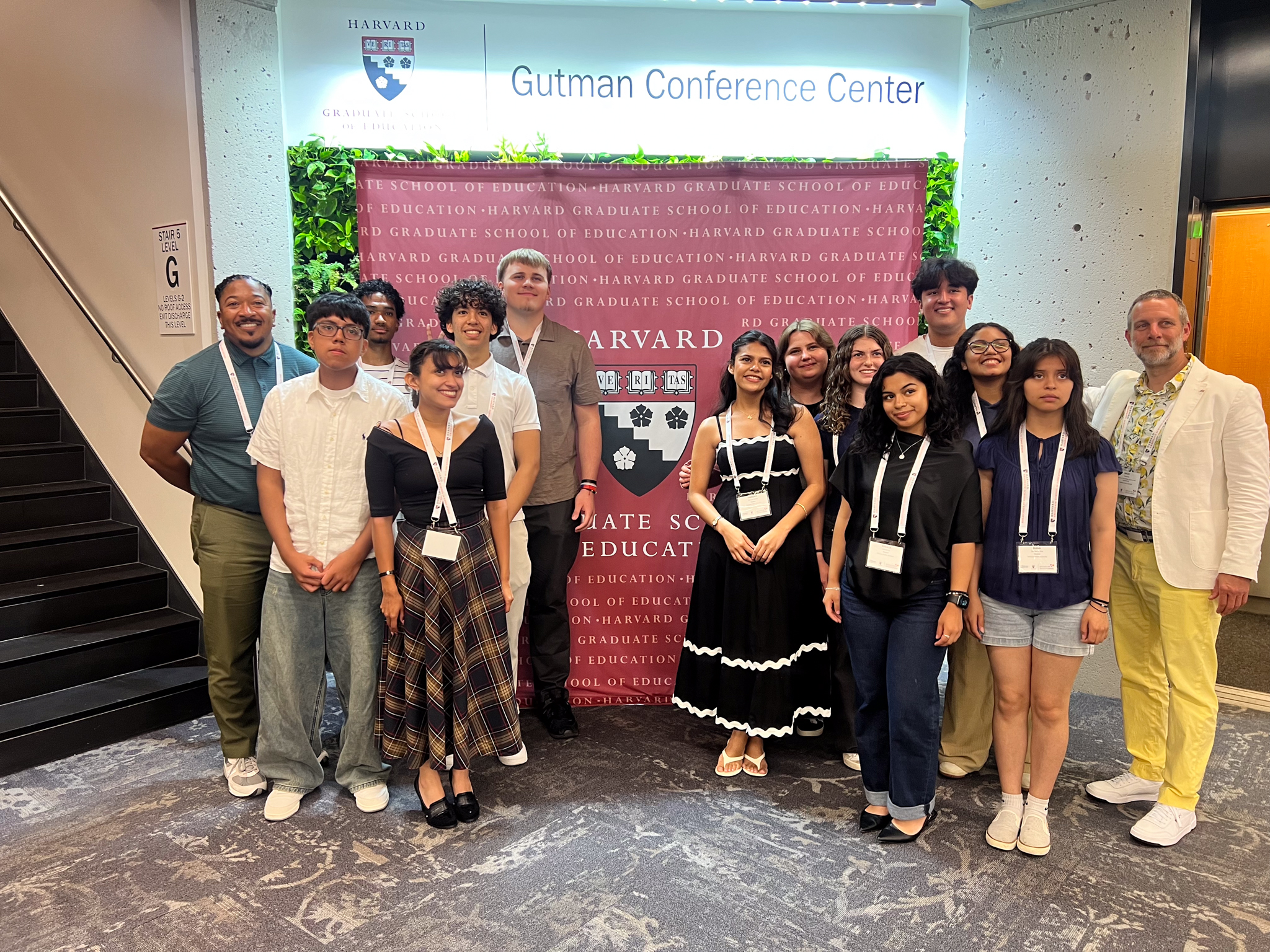 CHS students pictured in front of a banner at Harvard University. They gathered at Harvard to speak at a conference